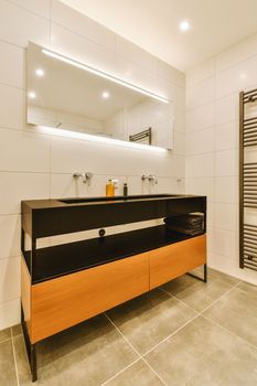 Sinks with mirrors and shower box with glass door in modern bathroom with white tiled walls