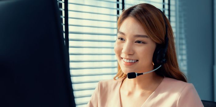 Competent female operator working on computer and while talking with clients. Concept relevant to both call centers and customer service offices.