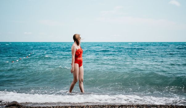 Young happy woman walks carefree on the seaside . Portrait beautiful young woman relax smile around beach sea ocean in holiday vacation travel trip