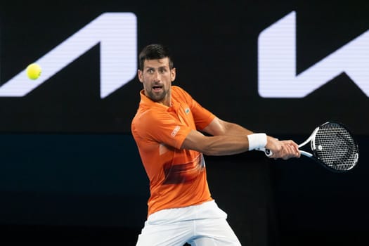 MELBOURNE, AUSTRALIA - JANUARY 13: Novak Djokovic of Serbia hits a shot to Nick Kyrgios of Australia in an Arena Showdown charity match ahead of the 2023 Australian Open at Melbourne Park on January 13, 2023 in Melbourne, Australia.
