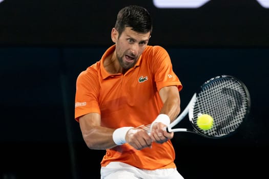 MELBOURNE, AUSTRALIA - JANUARY 13: Novak Djokovic of Serbia hits a shot to Nick Kyrgios of Australia in an Arena Showdown charity match ahead of the 2023 Australian Open at Melbourne Park on January 13, 2023 in Melbourne, Australia.