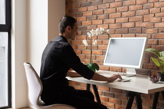 Young business man working at home with laptop on desk.