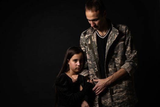 military man and daughter on a black background.