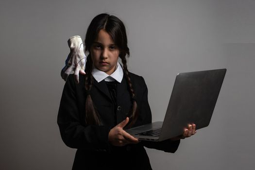 a girl in a black dress, Wednesday girl with a laptop.