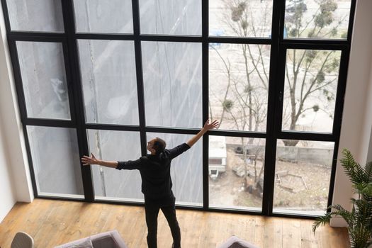 Happy businessman in office looking out the window