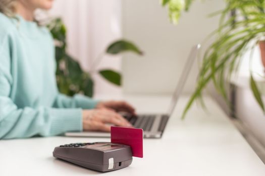 woman using payment card terminal to shop online with credit card, pos terminal