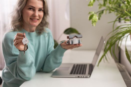 Hands of young woman holding model house, real estate insurance and banking concept