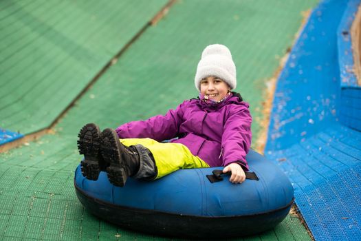 a little kid enjoying tubing down the wavy track ski resort.