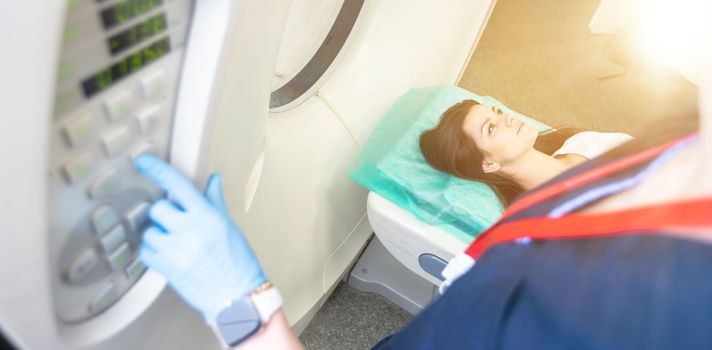 Radiologist with a female patient in the room of computed tomography