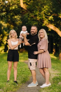 Happy family in the park of four people in the summer in the park in nature.