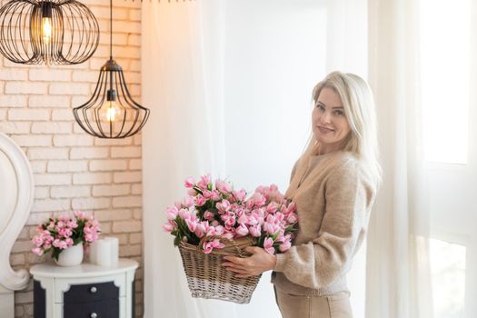 woman decorates her house with flowers. woman collects a bouquet at home in the kitchen. spring mood
