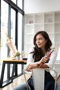 Pretty female artist sitting in the art studio.