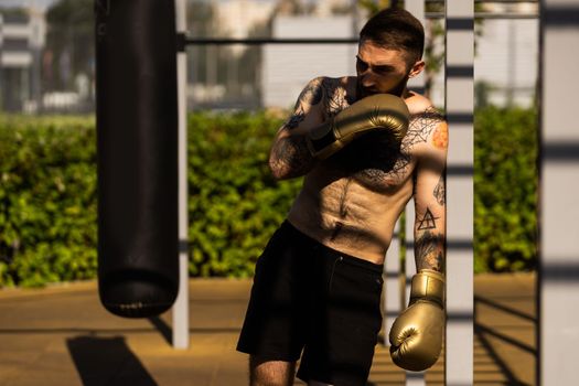 young naked boxer wearing protecting gloves