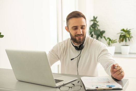 Bearded hipster style adult man working writing, freelance home sitting male typing on keyboard.