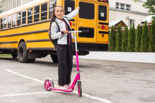 Beautiful little girl with backpack walking ready back to school, fall outdoors, education concept.