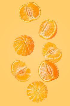 Isolated flying grapes. Seven whole and sliced mandarin fruits falling on yellow background with clipping path as package design element and advertising. Full depth of field.