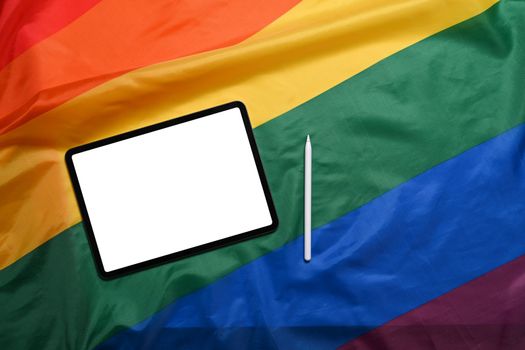 Digital tablet with blank screen on LGBT rainbow flag.
