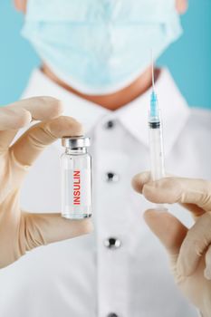 Diabetes treatment a bottle of insulin and a syringe with a needle in the hands of a doctor