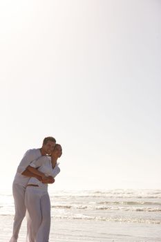 Having a romantic walk on the beach. a young couple embracing at the beach
