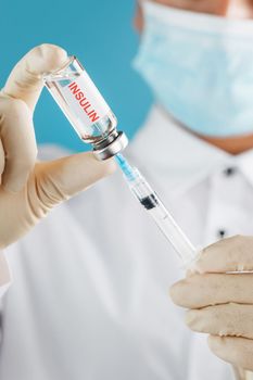 Diabetes treatment a bottle of insulin and a syringe with a needle in the hands of a doctor