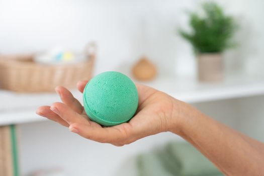 Closeup of a woman's hand with soap ball in the bathroom for skin and body care. Cosmetic and beauty - tenderness and wellness concept. High quality photo