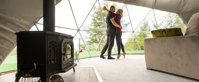 a couple in geo dome tents. Cozy, camping, glamping, holiday, vacation lifestyle concept. Outdoors cabin, scenic background