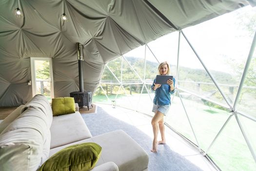 woman with tablet in dome tent.