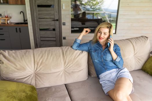 Portrait of beautiful young woman using her mobile phone at home