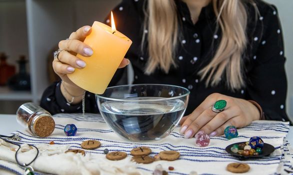 Woman fortune teller fortune telling wax candles. Selective focus. people.