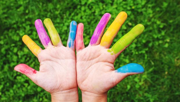 Children's hands in the colors of summer. Selective focus.arts