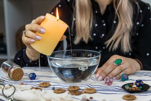 Woman fortune teller fortune telling wax candles. Selective focus. people.
