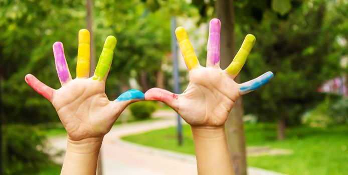 Children's hands in the colors of summer. Selective focus.arts