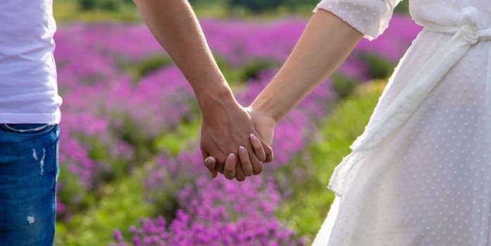 a man holds a girl by the hand in a field of lavender. Selective focus. Nature