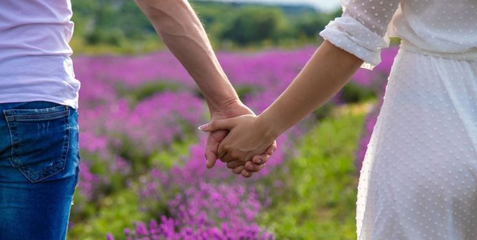 a man holds a girl by the hand in a field of lavender. Selective focus. Nature