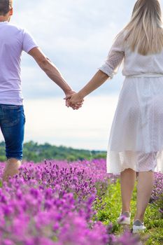 a man holds a girl by the hand in a field of lavender. Selective focus. Nature