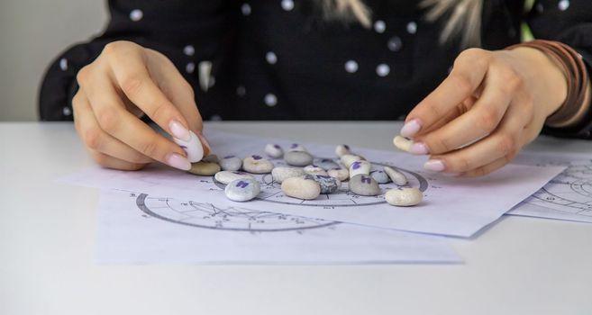 Woman numerologist astrologer counts numbers. Selective focus. People.