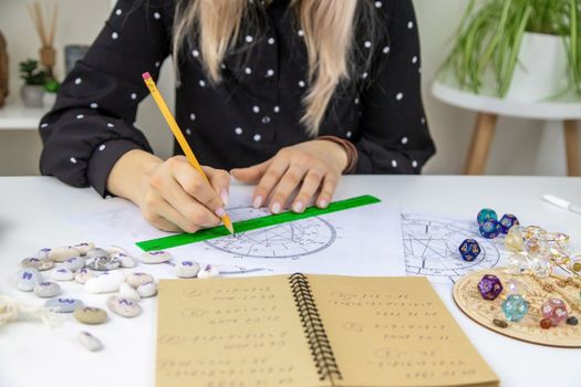 Woman astrologer draws a natal chart. Selective focus. People.