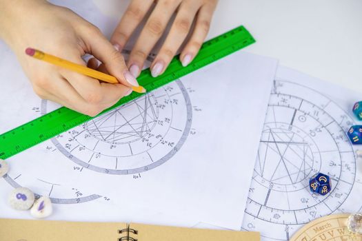 Woman astrologer draws a natal chart. Selective focus. People.