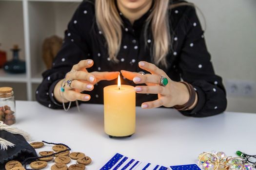 Woman fortune teller fortune telling on a candle. Selective focus. people.