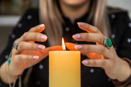 Woman fortune teller fortune telling on a candle. Selective focus. people.