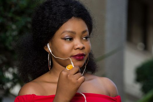 young woman talking on cell phone with earphone outside
