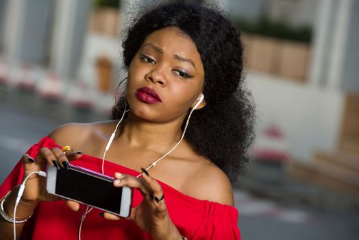 Beautiful young woman using laptop on a modern mobile phone with screen to copy text promotional content...