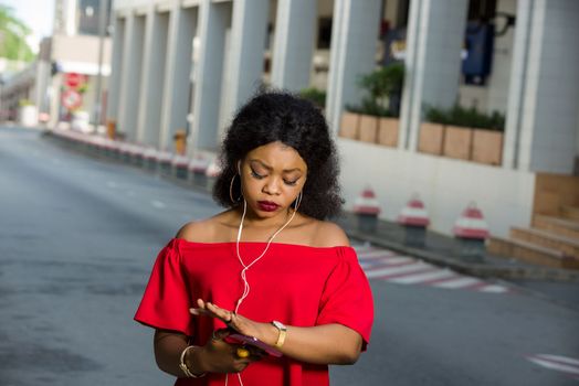 modern woman late look time on her watch while talking on the phone with earphones...