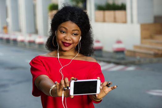 Beautiful young woman using laptop on a modern mobile phone with screen to copy text promotional content...
