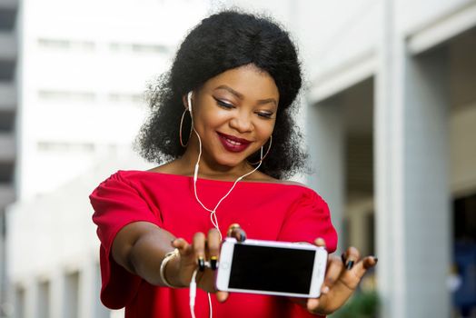 Beautiful young woman using laptop on a modern mobile phone with screen to copy text promotional content...