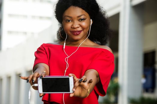 Beautiful young woman using laptop on a modern mobile phone with screen to copy text promotional content...
