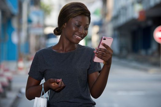young girl is taking pictures with mobile phone after shopping in the city