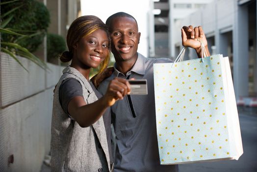 young happy couple holds shopping bags with a credit card out.Concept of shopping and free time.