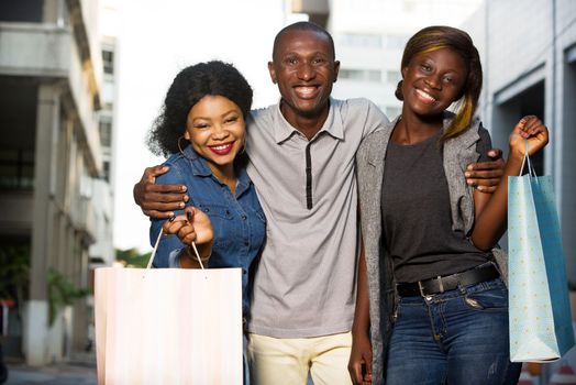 Group of happy young people doing shopping together, holding shopping bags outdoors .Outdoor shopping group concept.