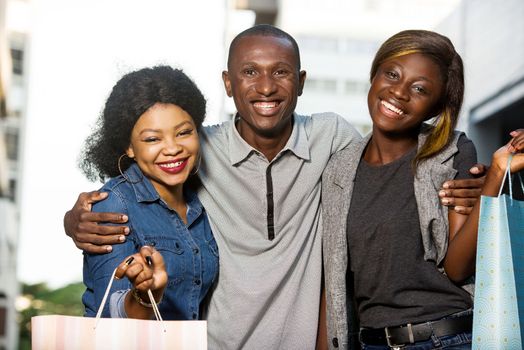 Group of happy young people doing shopping together, holding shopping bags outdoors .Outdoor shopping group concept.